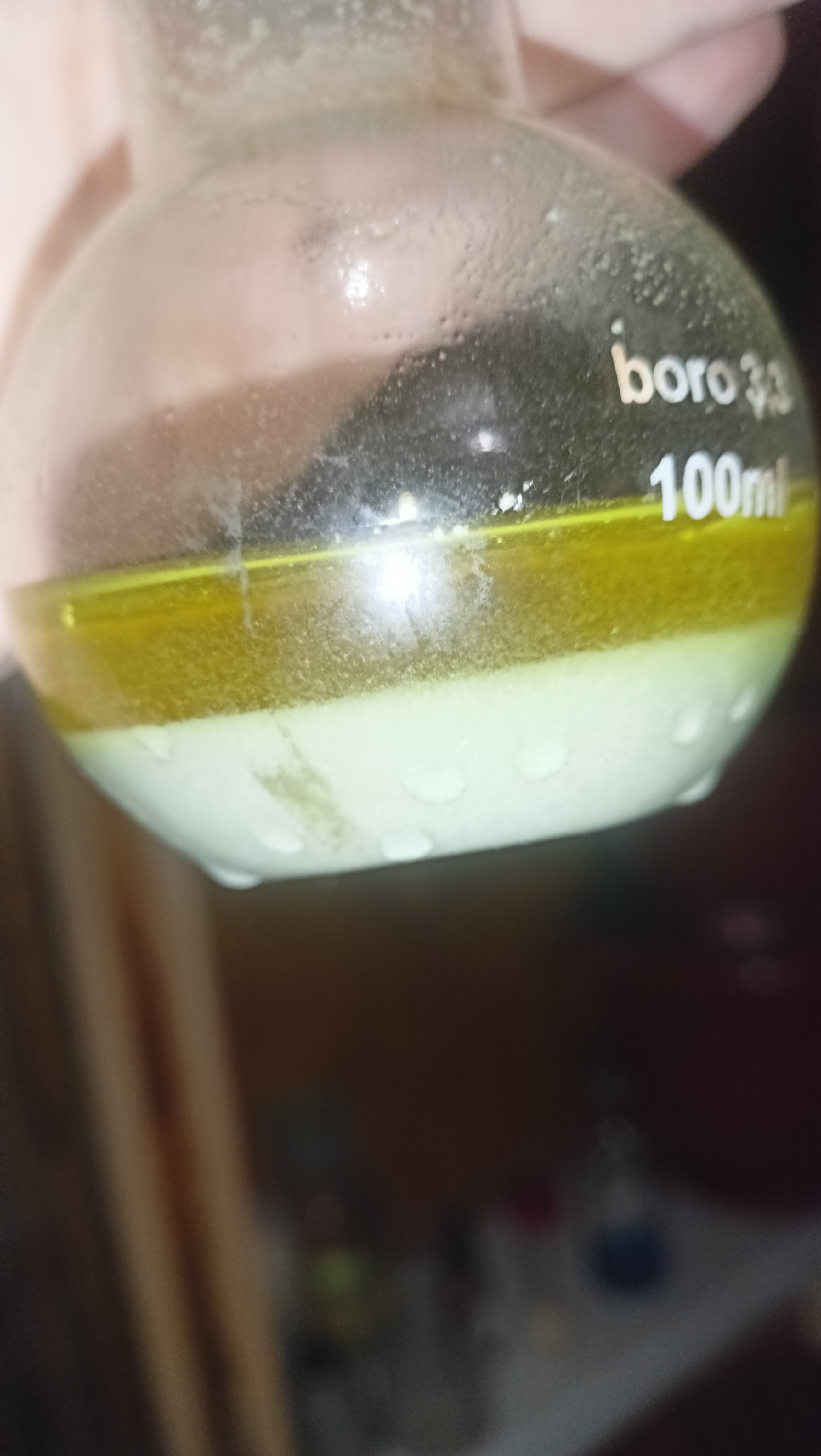 Flask filled with yellow product in a yellow solutino